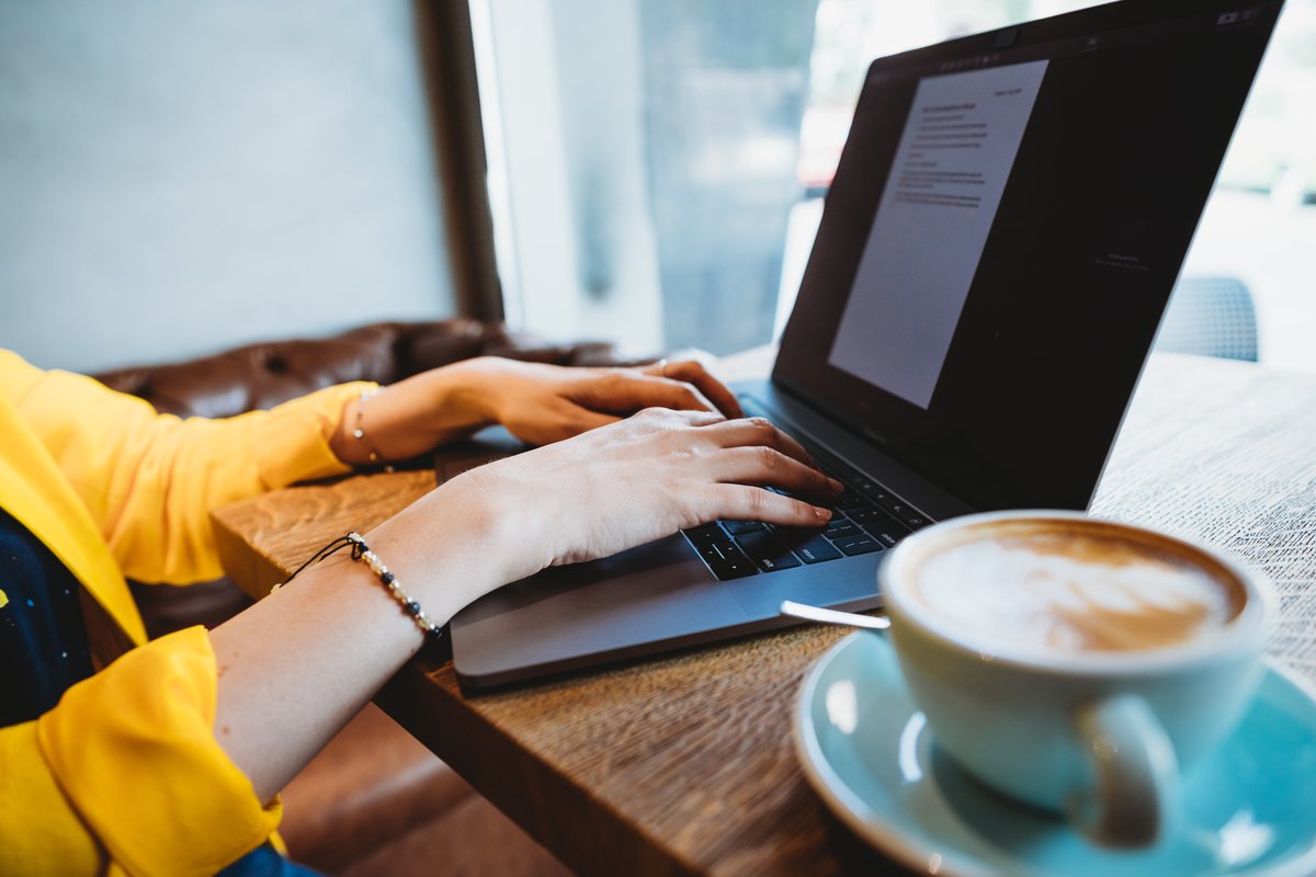 A laptop and a cup of coffee on a table, ready for a quick website check